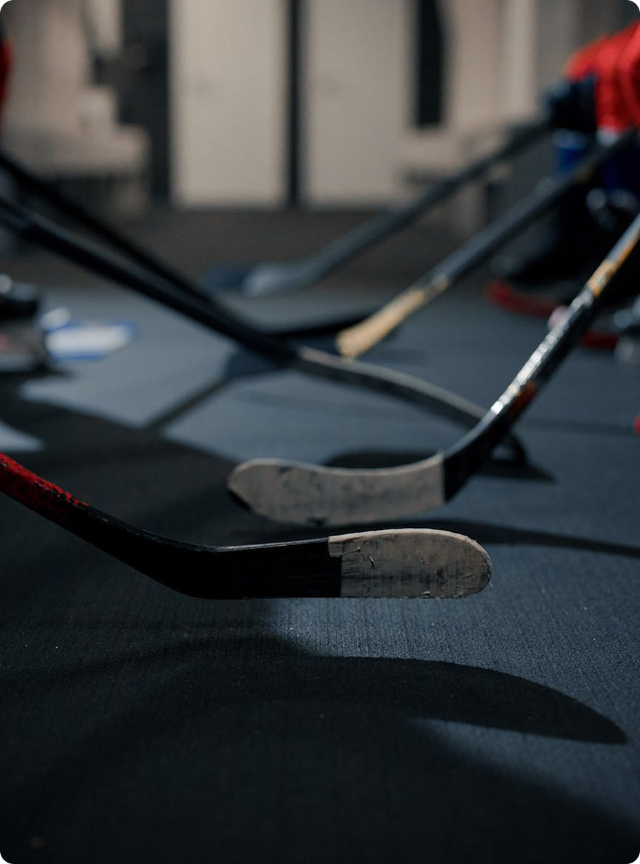 Hockey sticks lined up on the bench