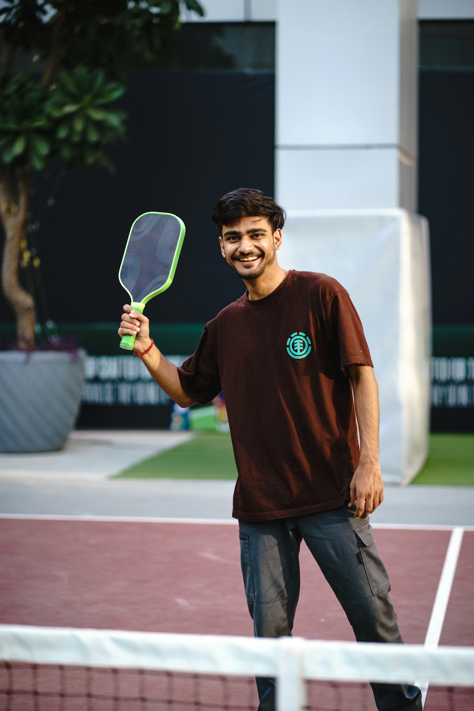 Player holding a pickleball paddle on an outdoor court