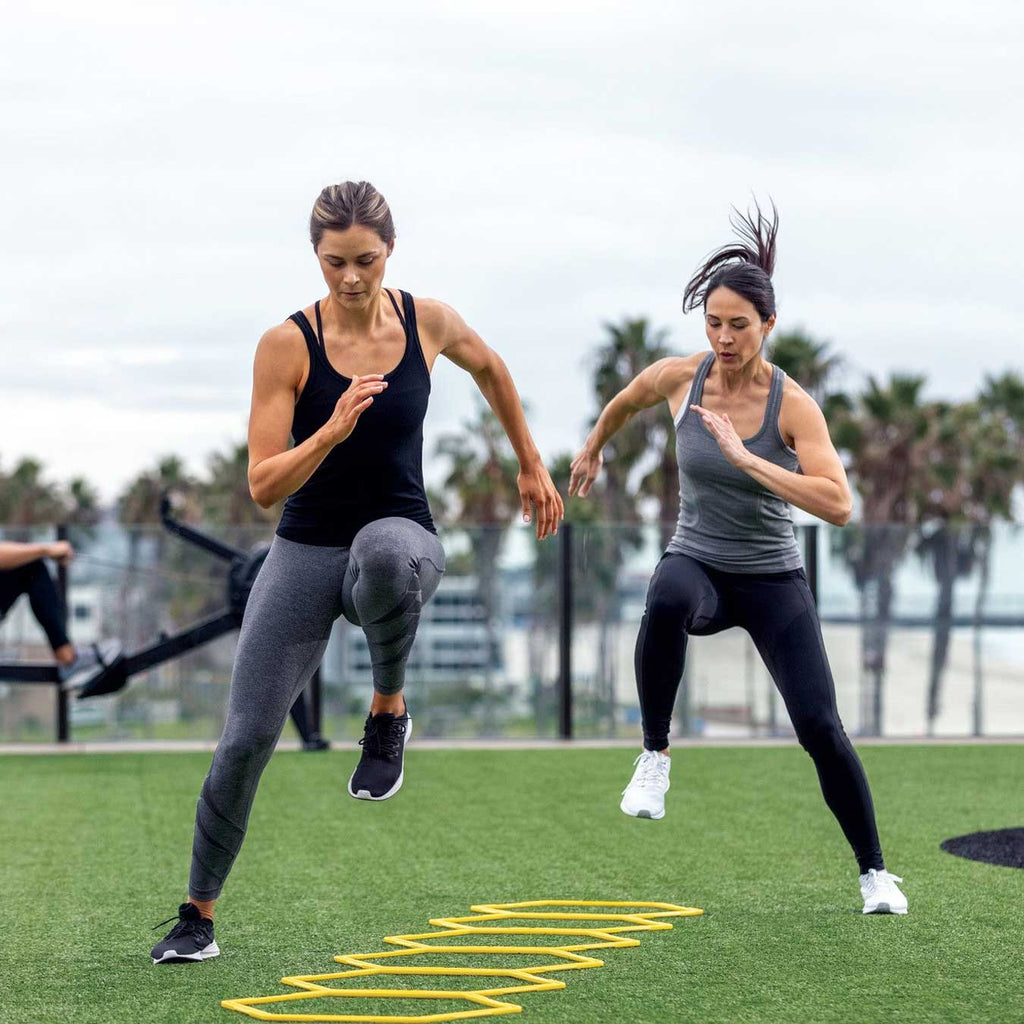 Athletes running the SKLZ Speed Web in ladder configuration outdoors