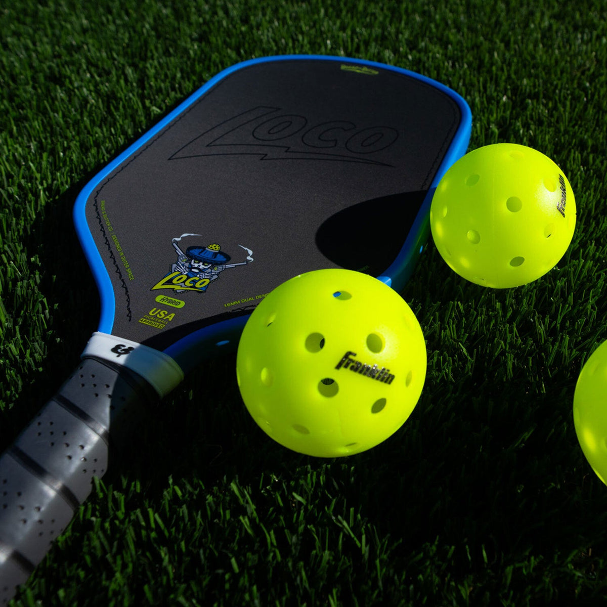 Bread & Butter Loco Hybrid Pickleball Paddle - Blue/Gray, on turf with balls