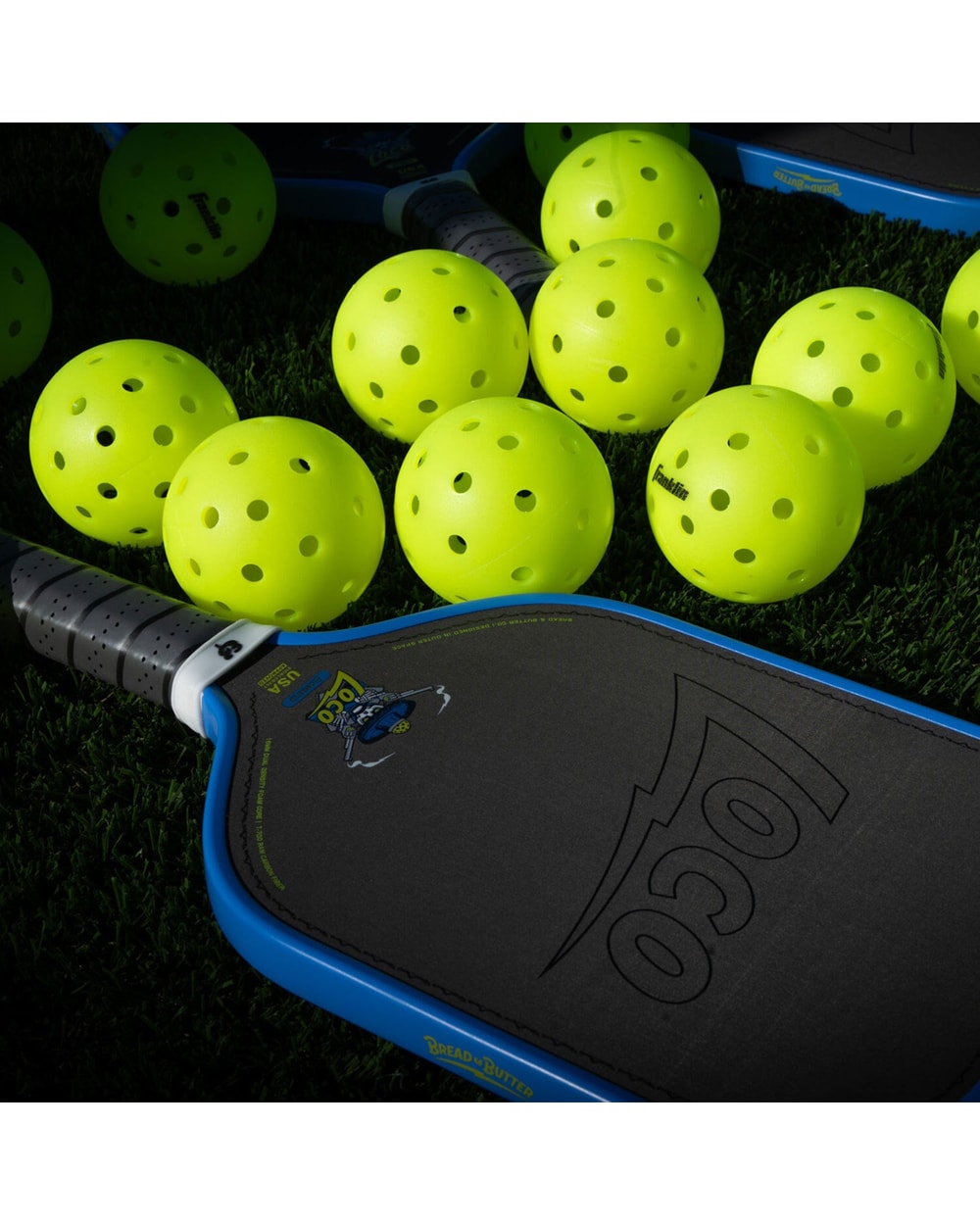 Bread & Butter Loco Elongated Pickleball Paddle - Blue/Gray, on turf with balls
