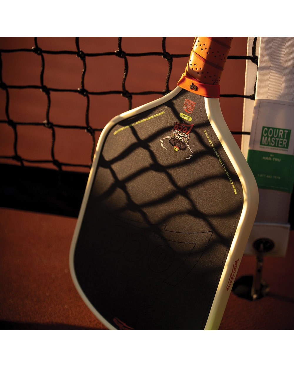 Bread & Butter Loco Hybrid Pickleball Paddle - Cream/Tan, angled view at net