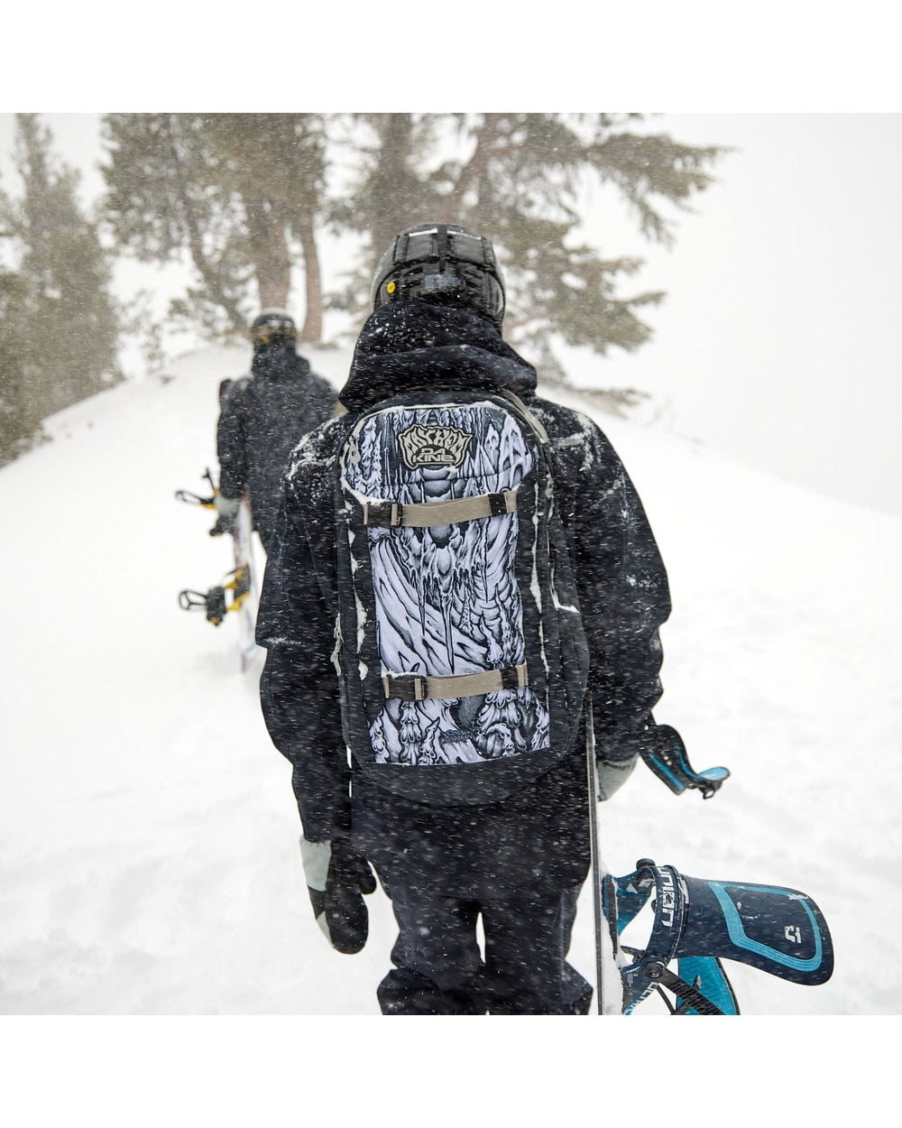 Dakine Mission 25L Backpack X Mayhem - worn by a snowboarder in the trees