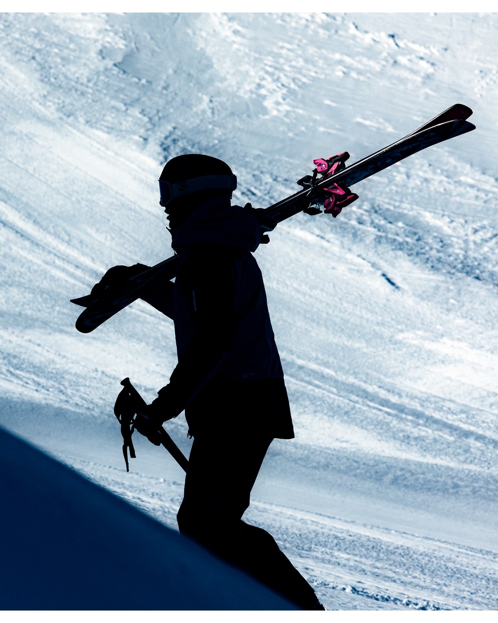 Skier carrying skis fitted with Salomon Strive 14 Multinorm bindings